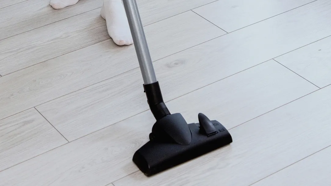 cropped photo of a girl in blue jeans vacuuming the