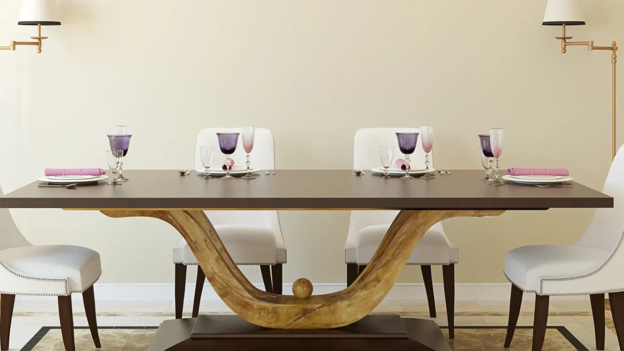 A dining room interior with a sculptural base dining table, chairs, and lamps.