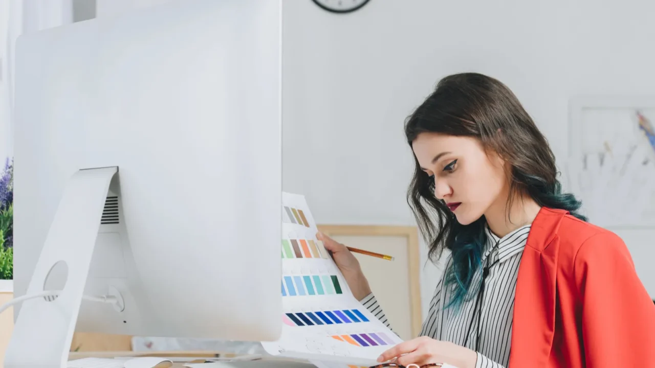 female designer working with palette by working table with computer