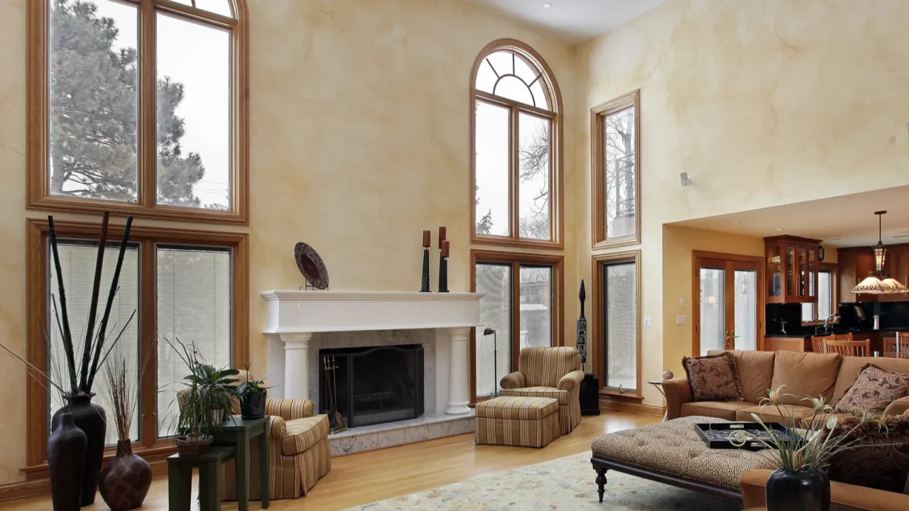 A bright living room with high ceilings, large windows, and comfortable seating.