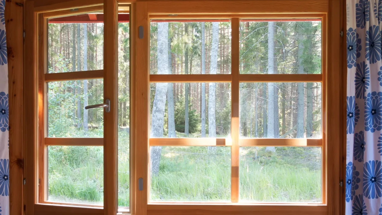 open window with natural wooden frame and blue flower curtains