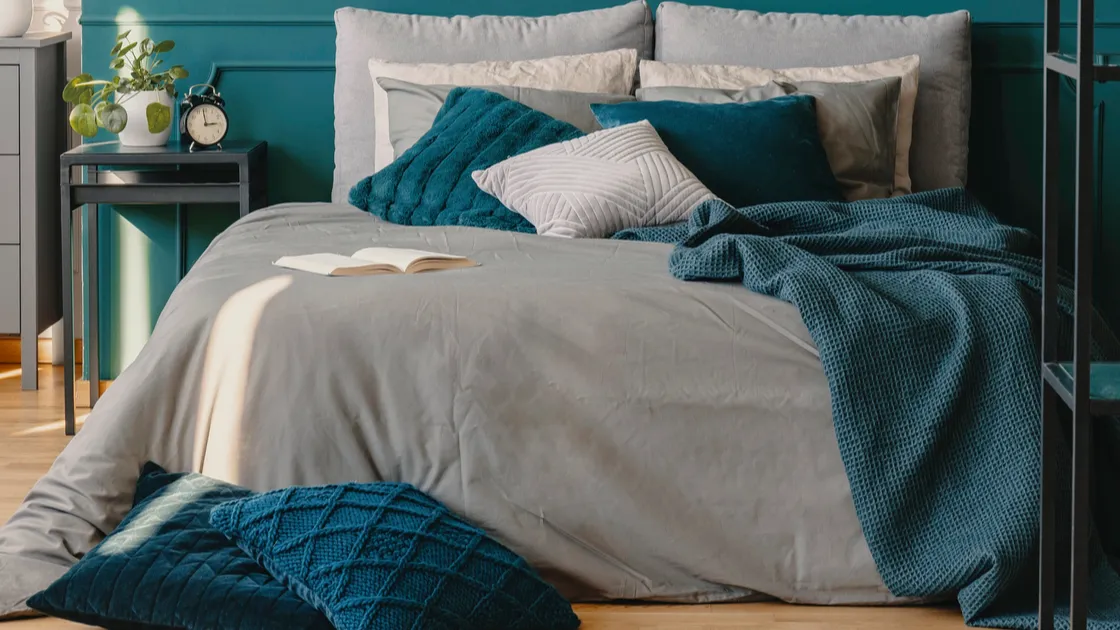 two industrial lamps above comfortable double bed with cozy bedding