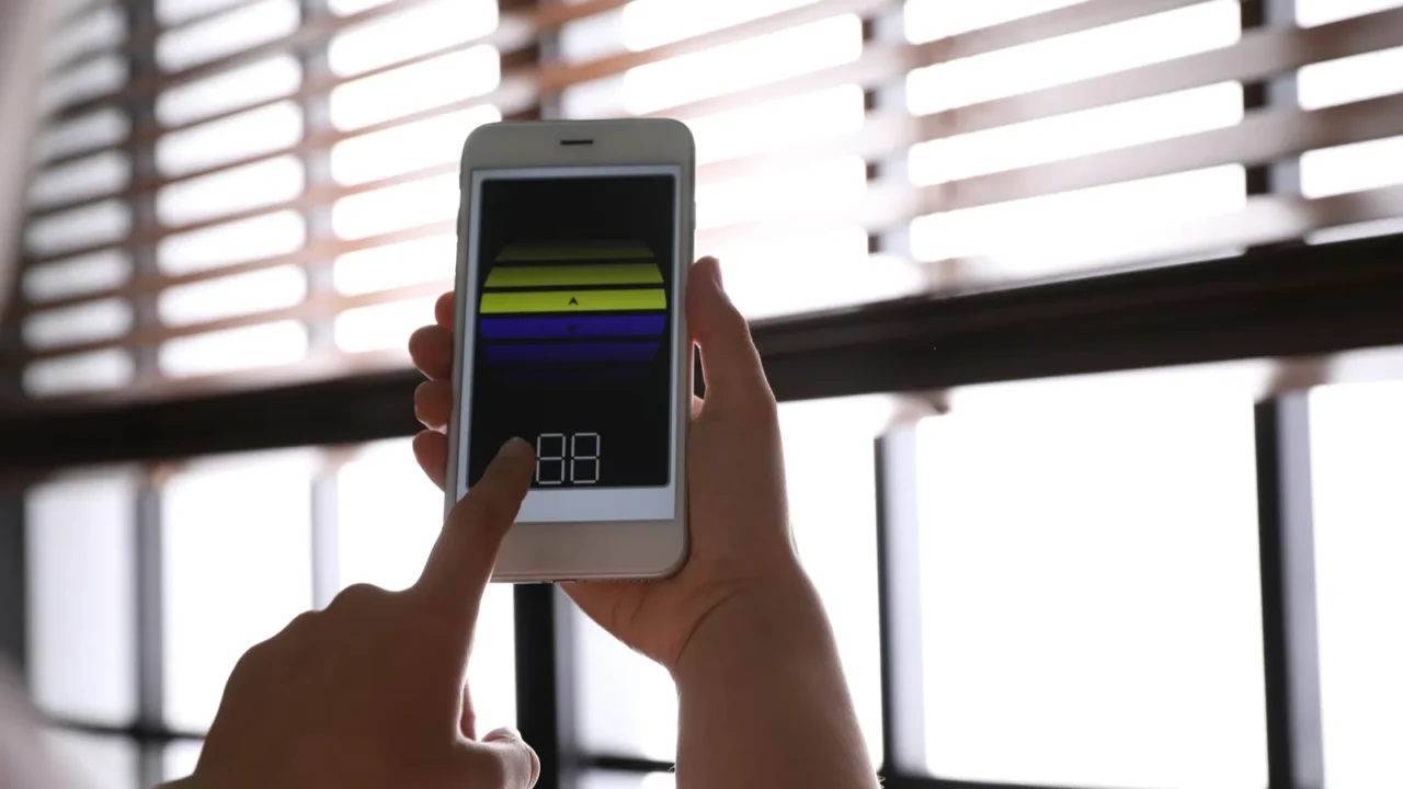 A woman using a smartphone to control the blinds.