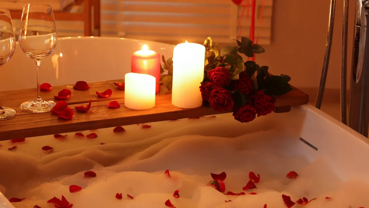 wooden tray with wine burning candles and rose petals on