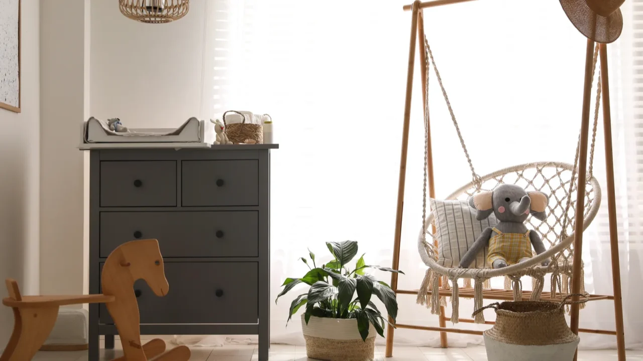 baby room interior with modern changing table and wooden swing