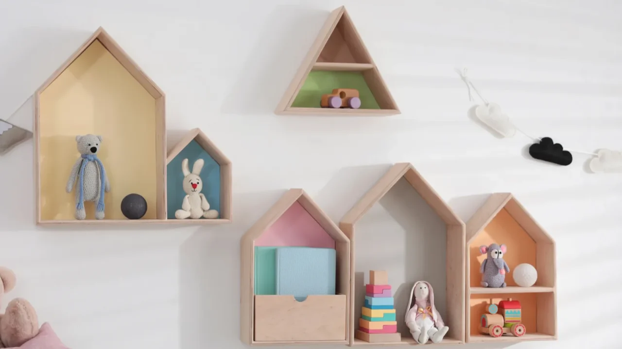 cute house shaped shelves and garlands on white wall indoors