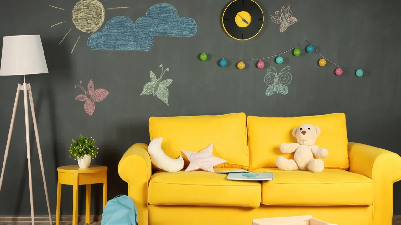 A playful living room with a yellow sofa, stuffed animals, and wall decorations.