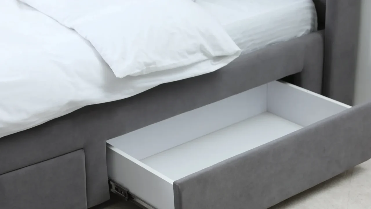 A gray bed with under-bed storage for bedding and essentials.