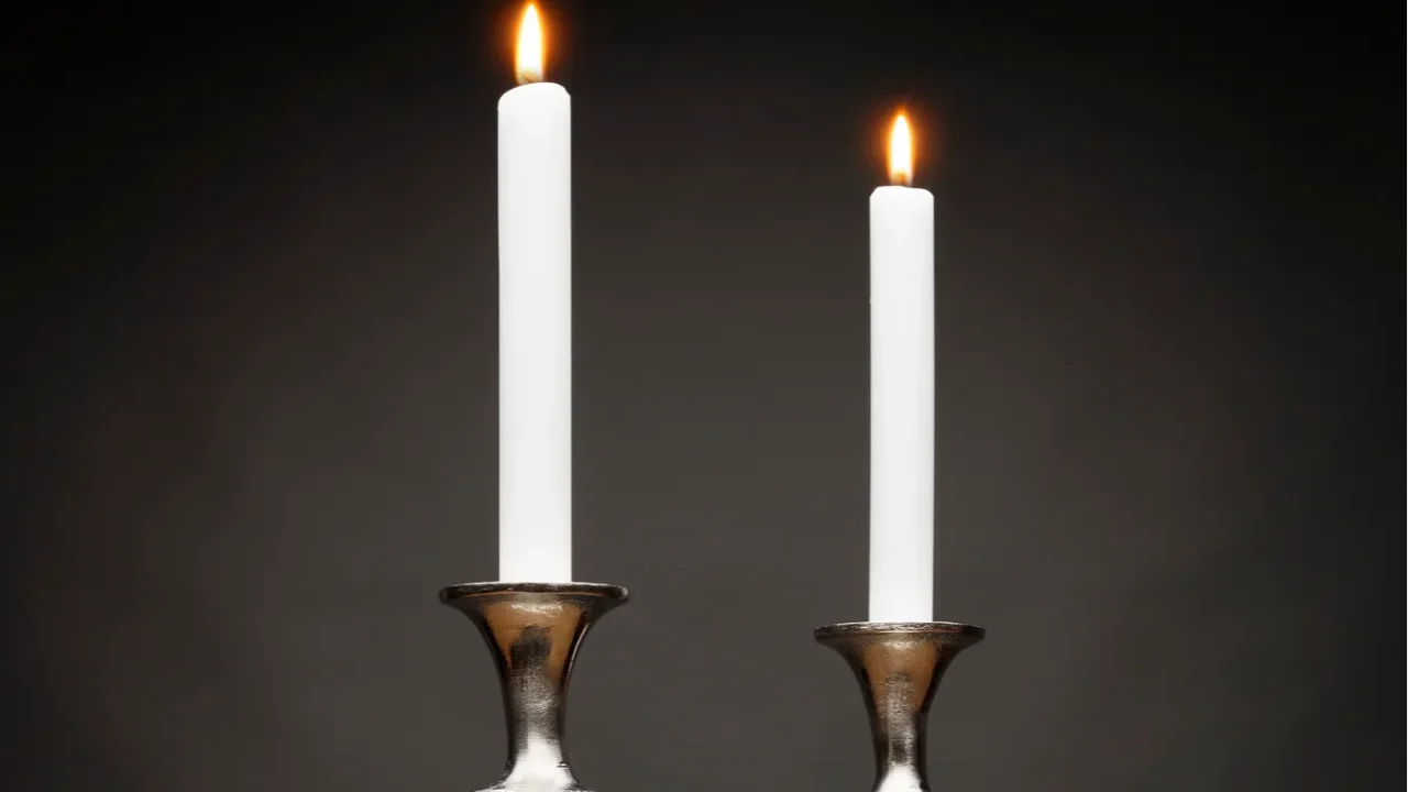 2 tall silver candle holders and glowing candles shot on