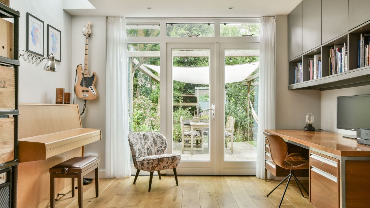 A cozy home office featuring a piano and garden view.