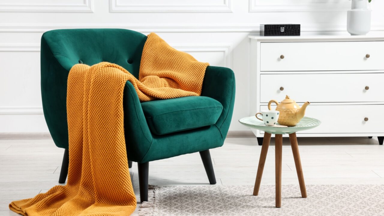 A cozy reading nook with a plush armchair, a small side table, and warm ambient lighting.