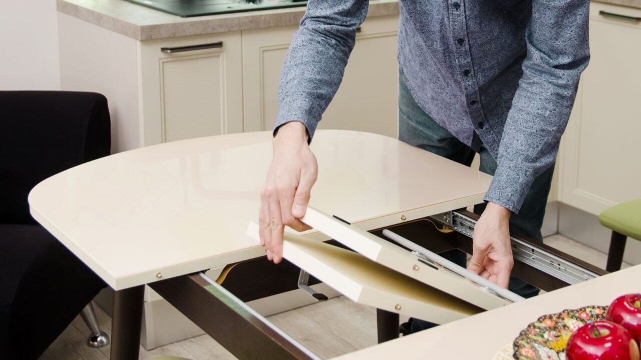 A man securely placing pallets on a sliding dining table.