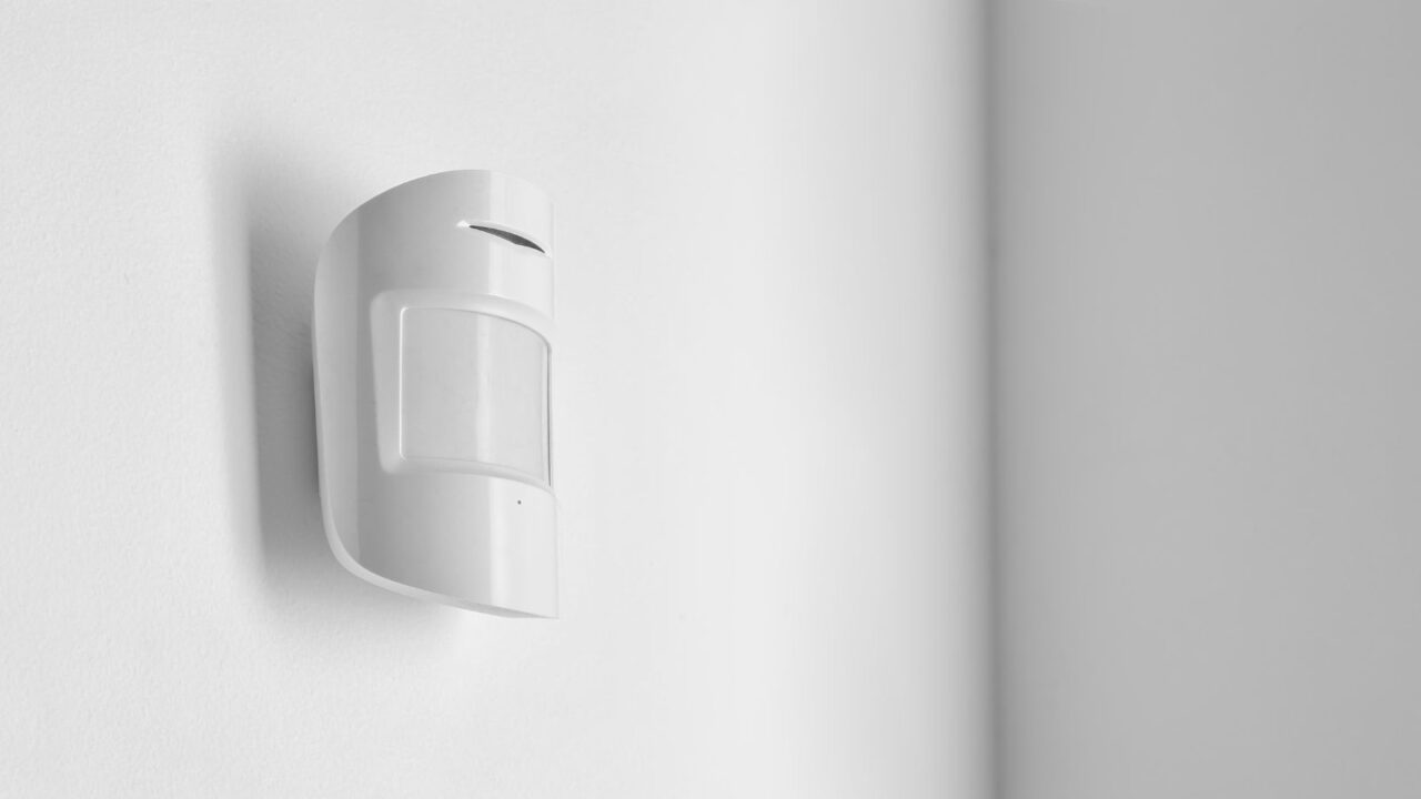 A motion-activated light attached on a white wall.