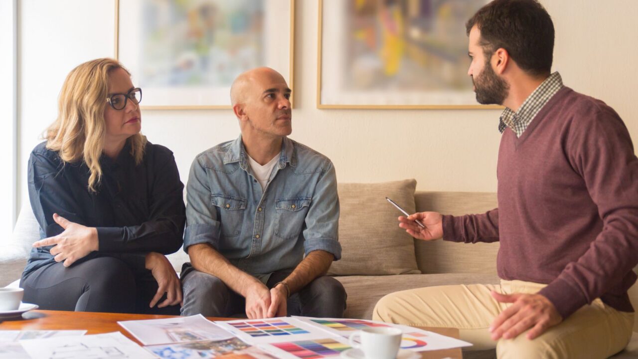 Interior designer talking with clients at home.