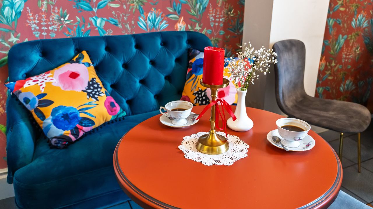 Vibrant dining nook with a teal tufted sofa, colorful cushions, and decorative accents.