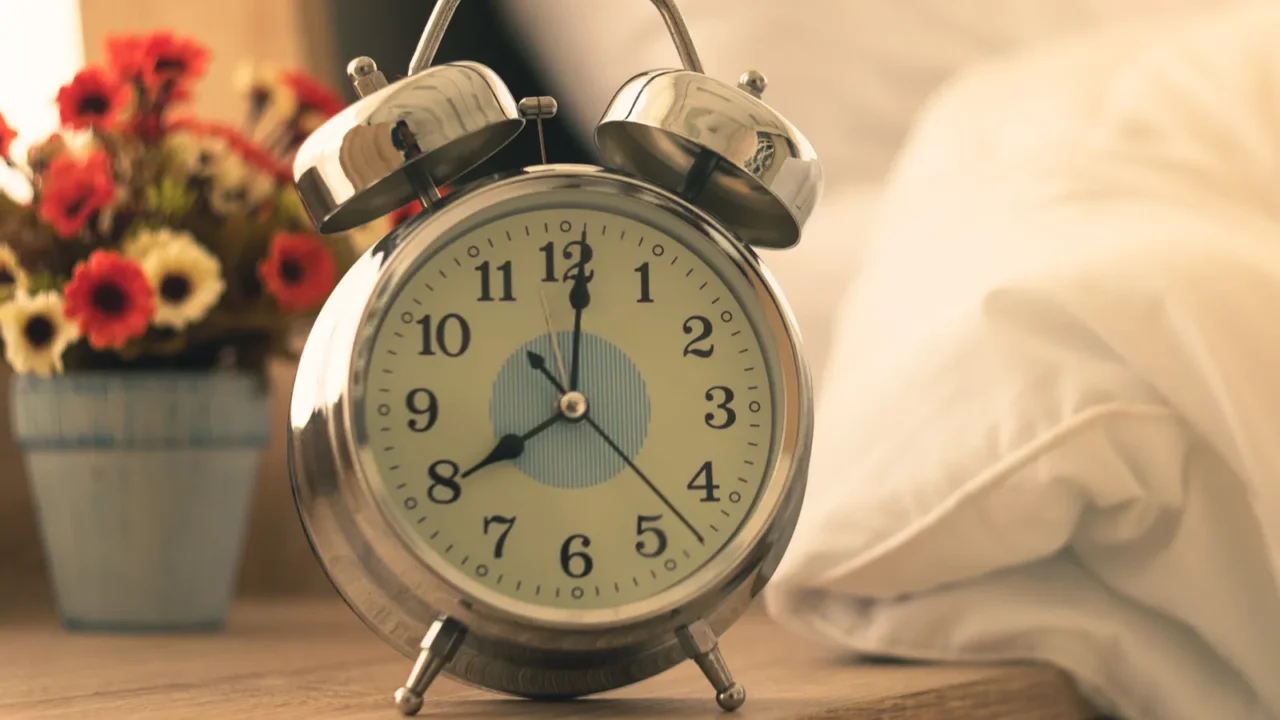 alarm clock analog vintage antique on table beside the bed