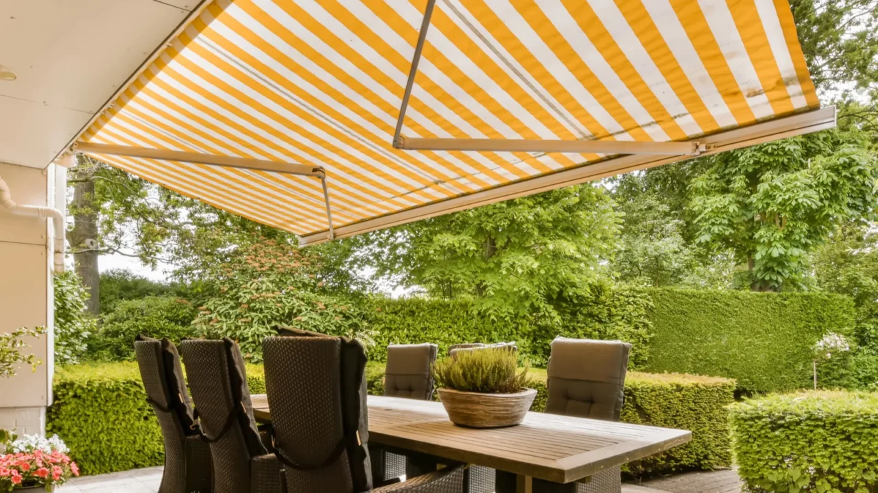 an outdoor dining area with table and chairs under a