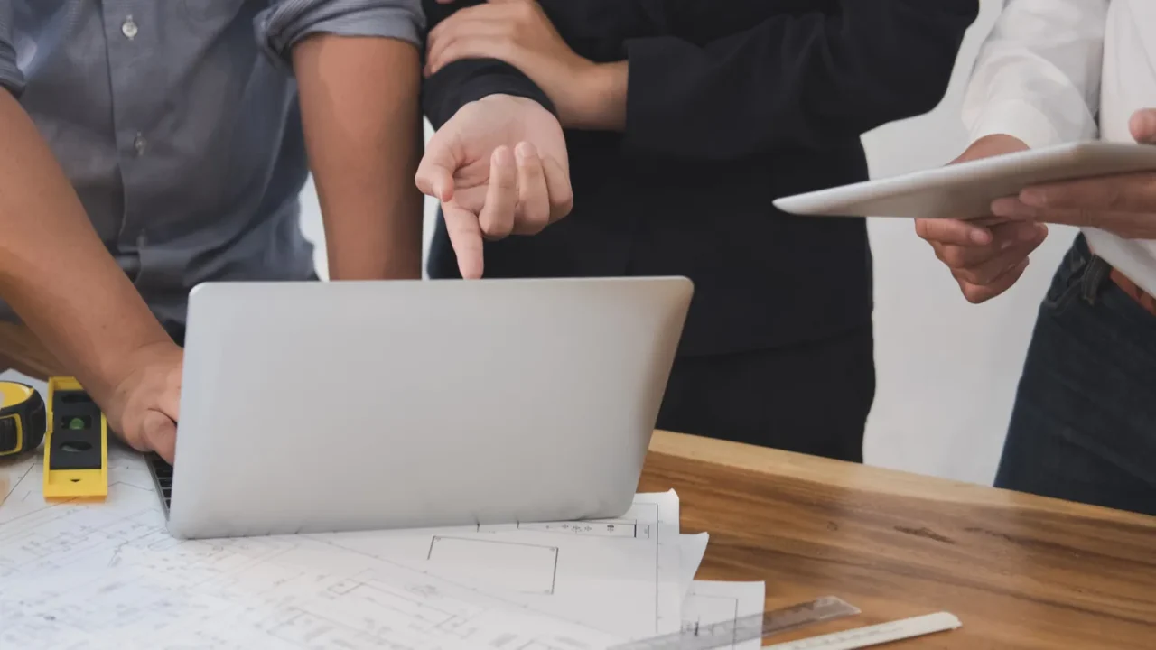 Group of people reviewing plans on a laptop.