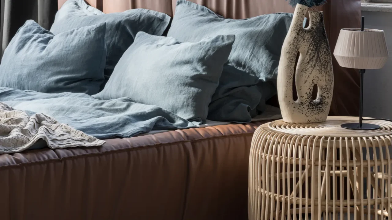 big and comfortable bed with leather headboard and blue flax