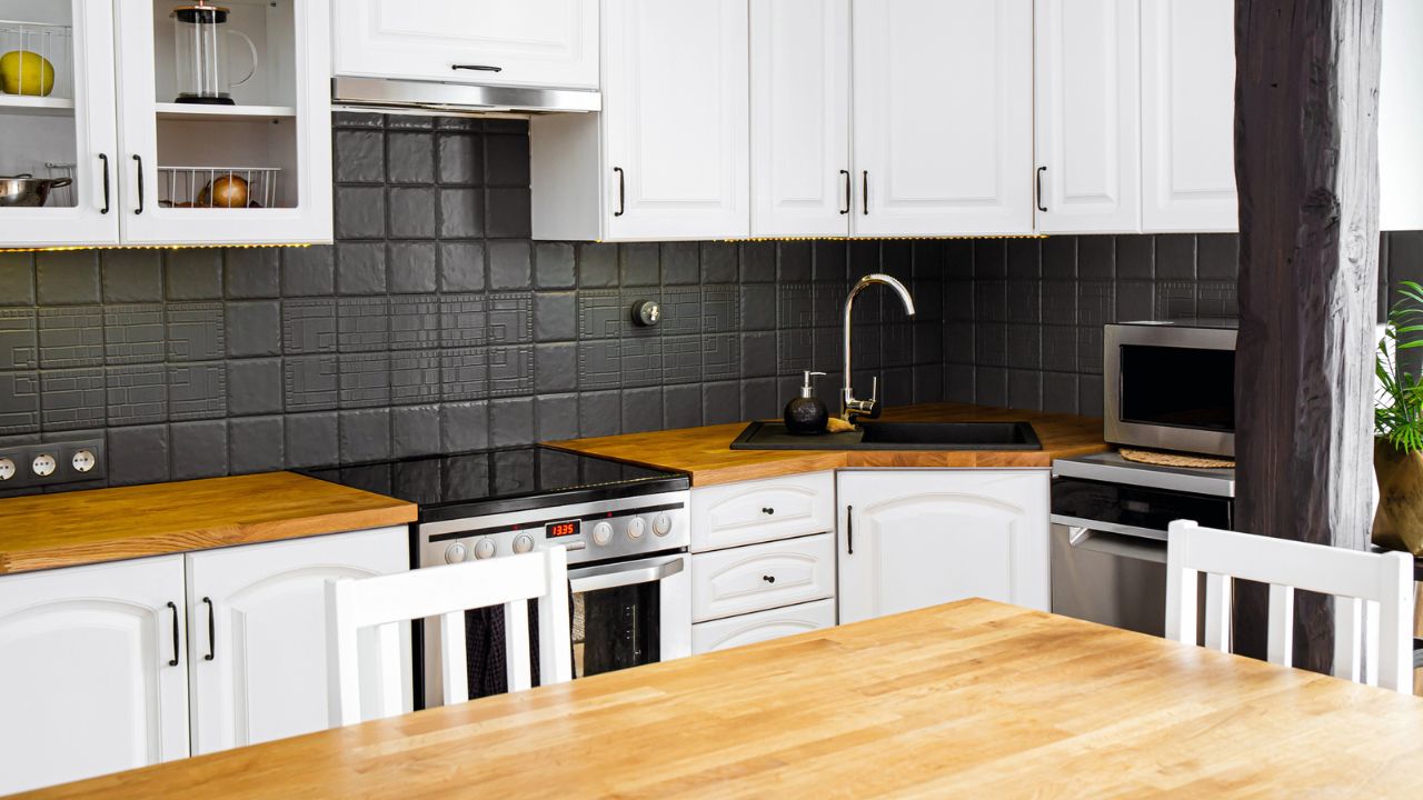 A cozy kitchen with white cabinets and wooden countertops.