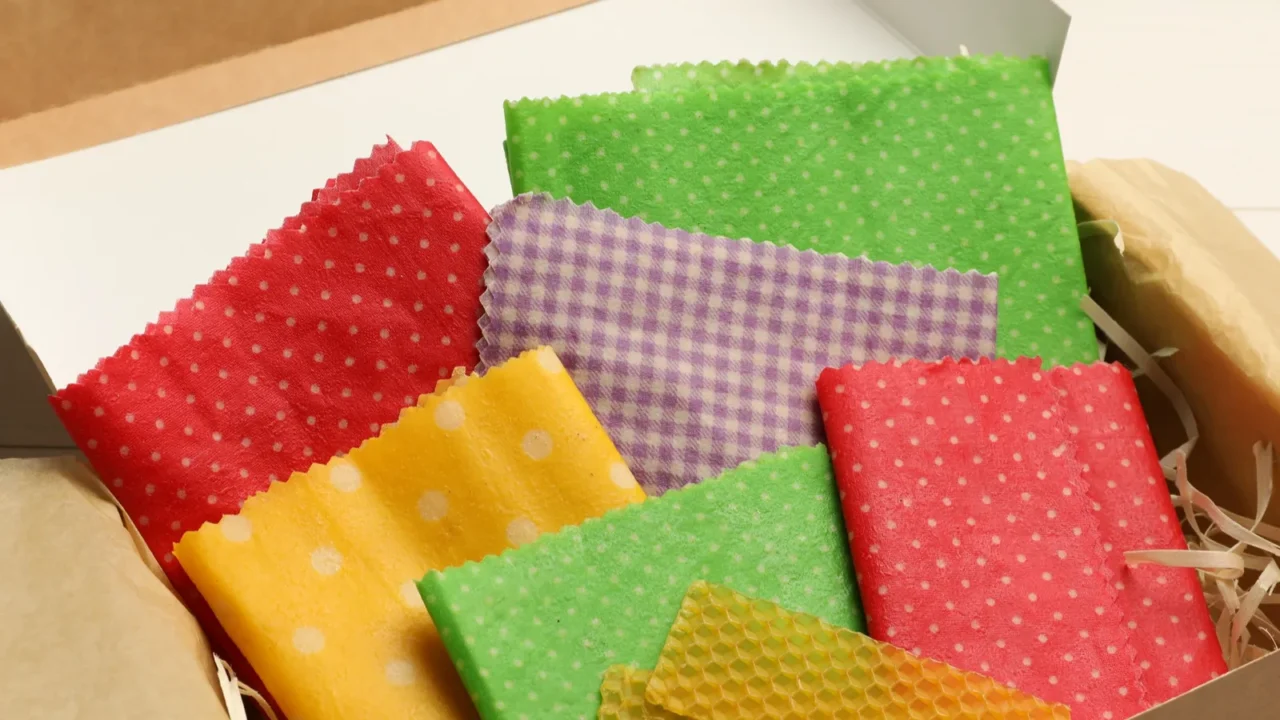 colorful beeswax food wraps in box on white wooden table