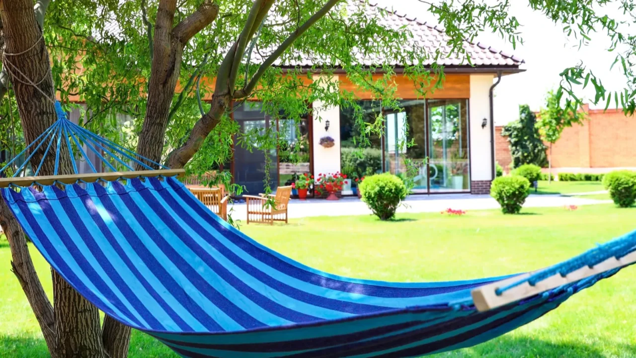 A chill zone in the garden with a blue hammock hanging from the trees.