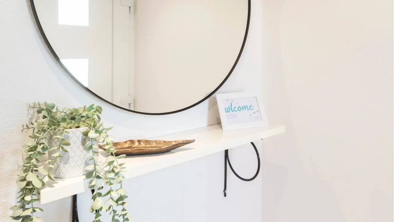 detail of moder round mirror with welcome plaque and