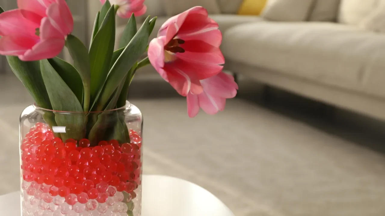 different color fillers and tulips in glass vase on white