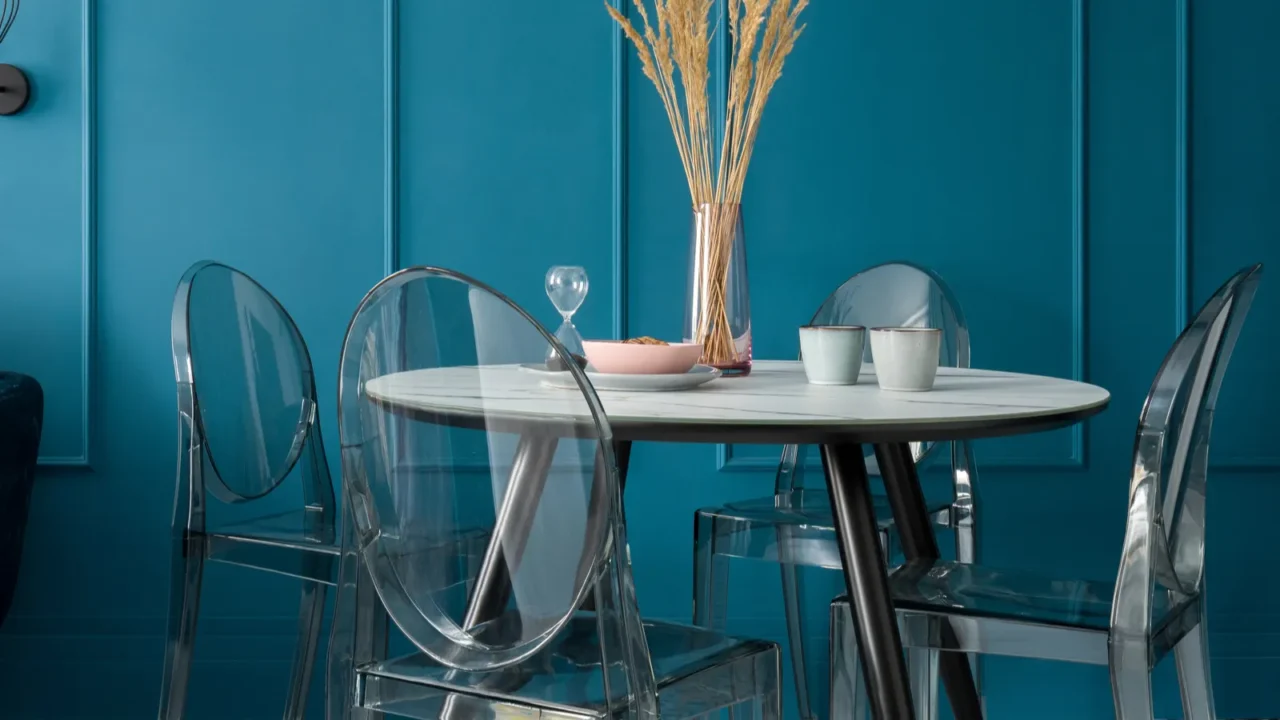 fancy dining table with marble style countertop with four transparent chairs