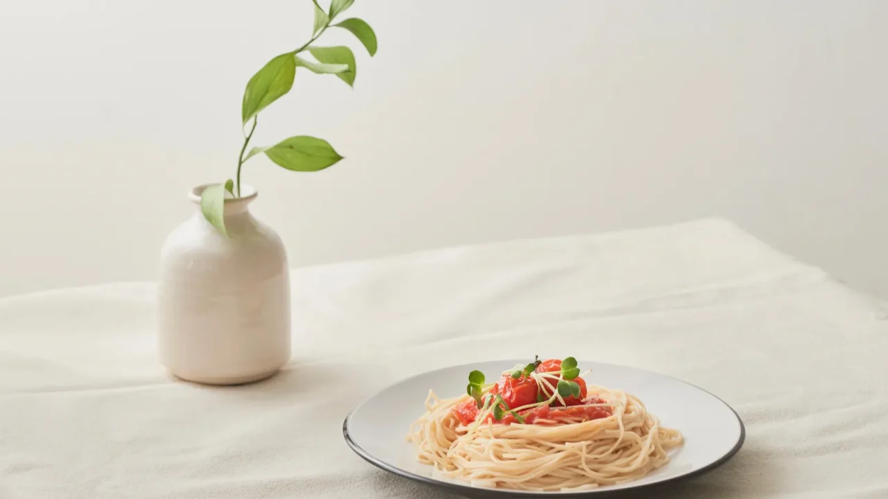 food spaghetti bolognese sauce in white dish and a vase