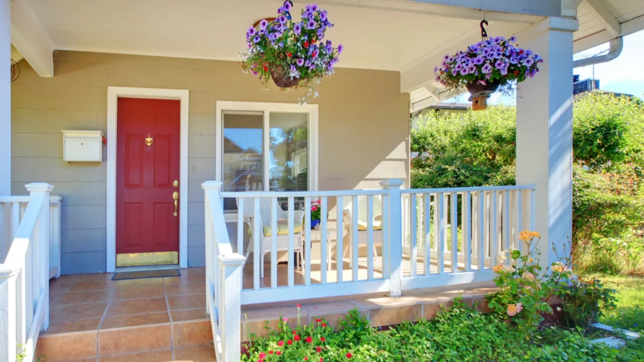 grey old house front porch exterior with red door