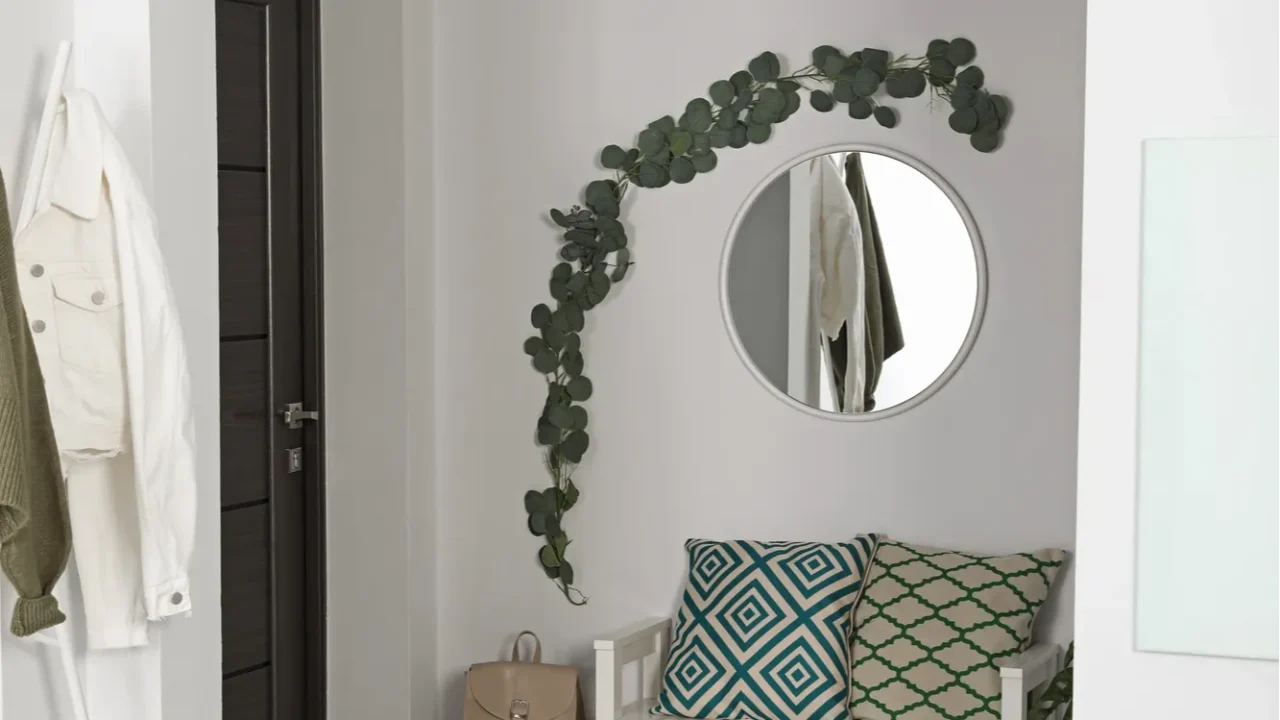 hallway interior with stylish furniture and round mirror on light
