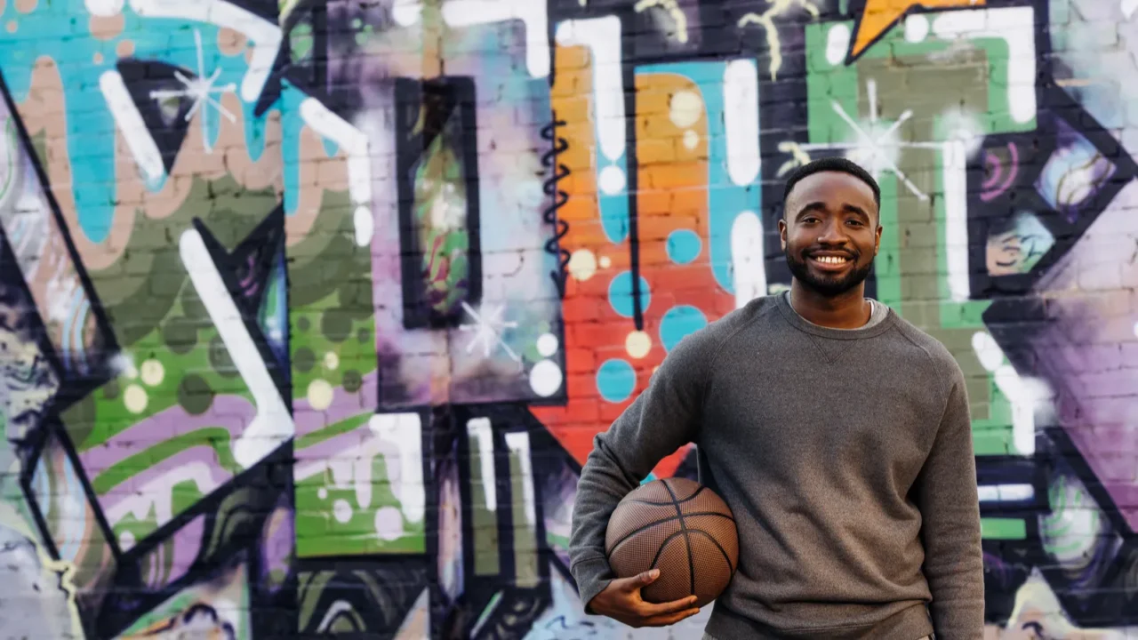 handsome african american man with basketball ball looking at camera