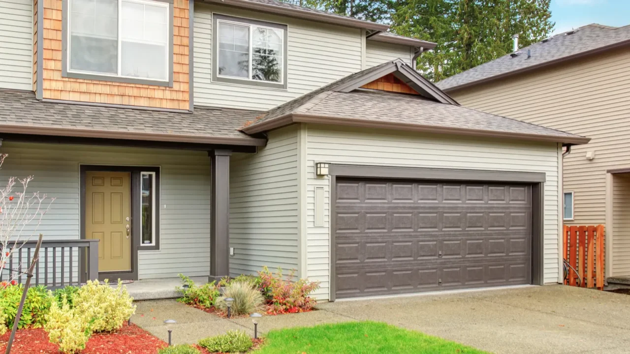 A cozy house exterior with a mix of vertical siding and natural wood accents, featuring a welcoming porch.