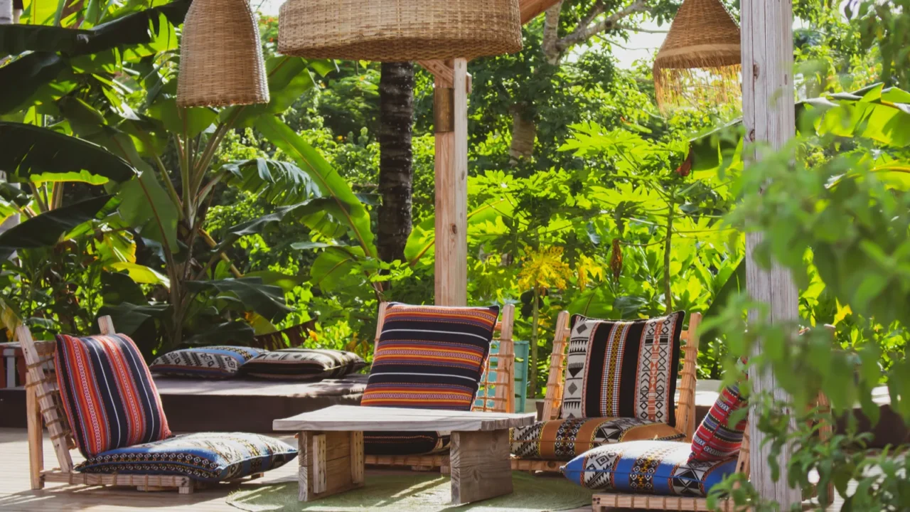 lounge chairs with pillows and table under straw lamps in