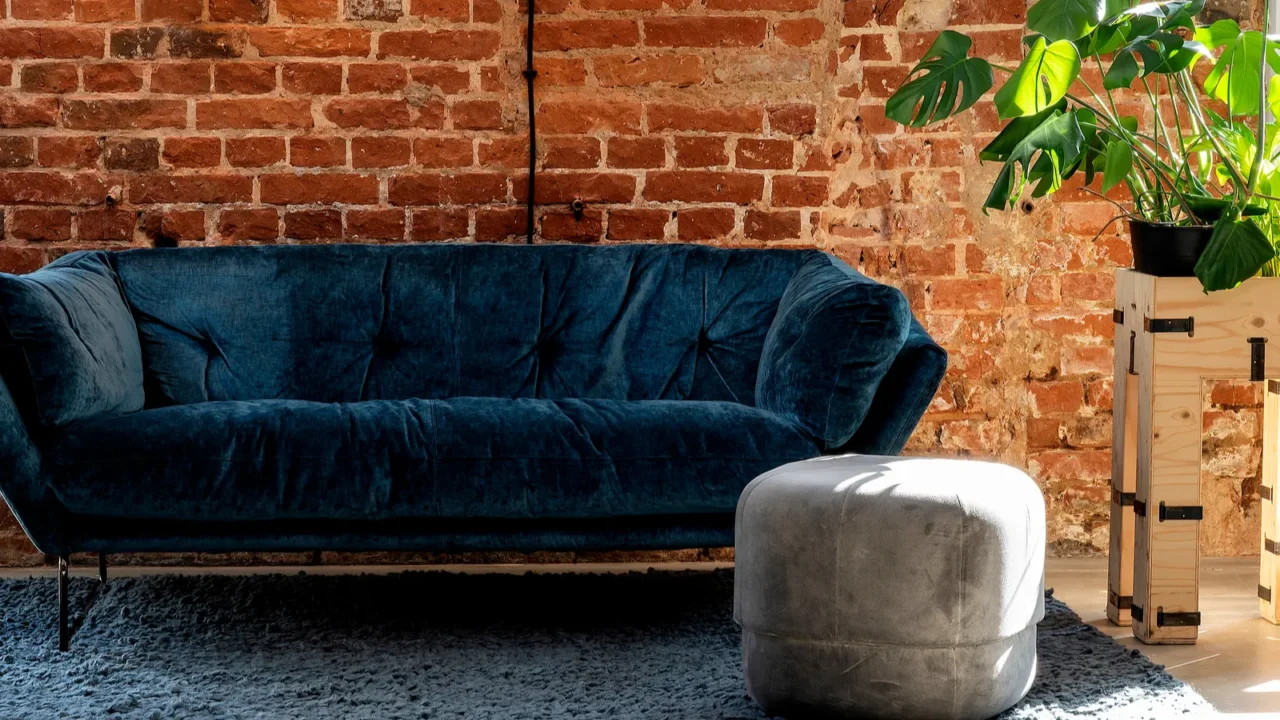 navy sofa in the living room with plants and brick