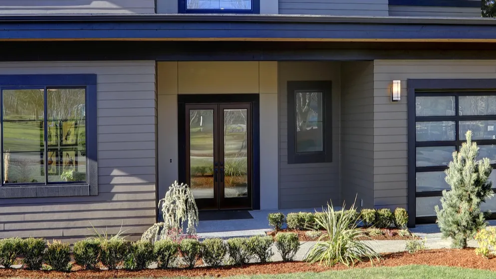 new construction home with low slope roof and brown siding