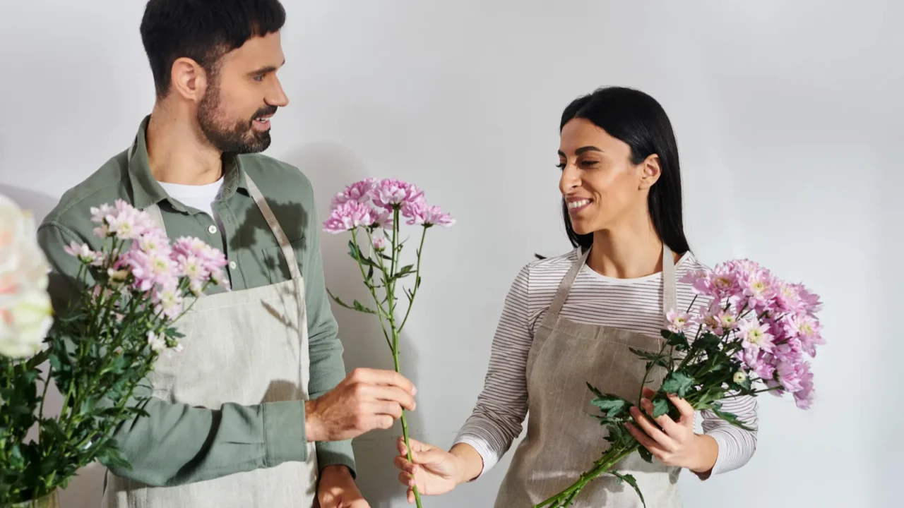 owners of a florist shop joyfully arrange flowers while showcasing