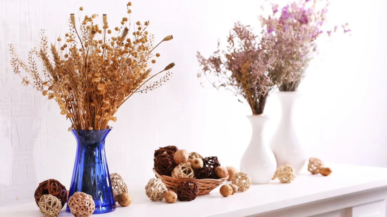 still life of dried flowers on white wall background
