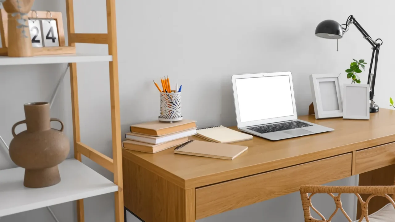 stylish workspace with modern laptop and desk lamp near white