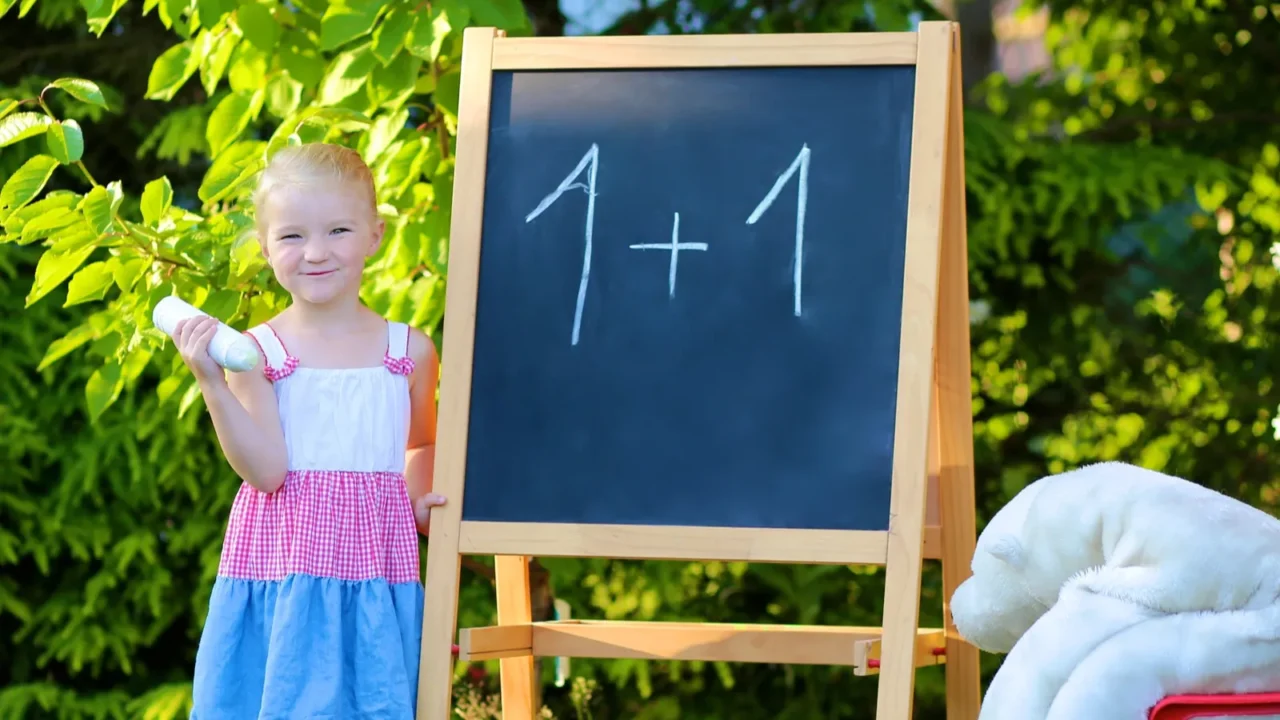 toddler girl playing teacher with her toys