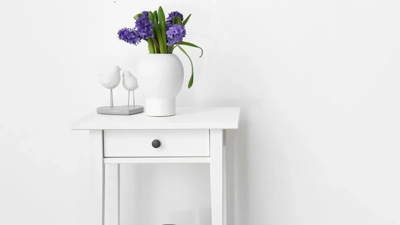 vase with flowers and stylish decor on standing desk near