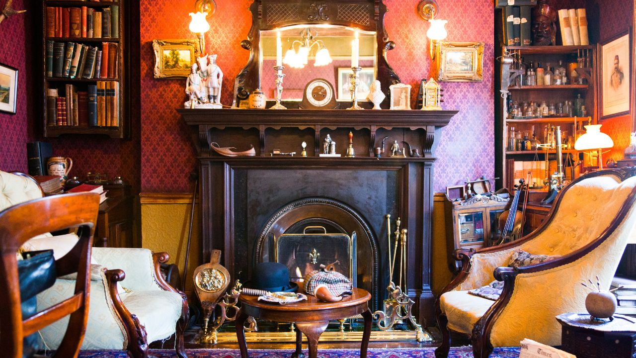 Cozy, vintage-style living room with a dark wood fireplace, yellow upholstered chairs, and warm lighting.
