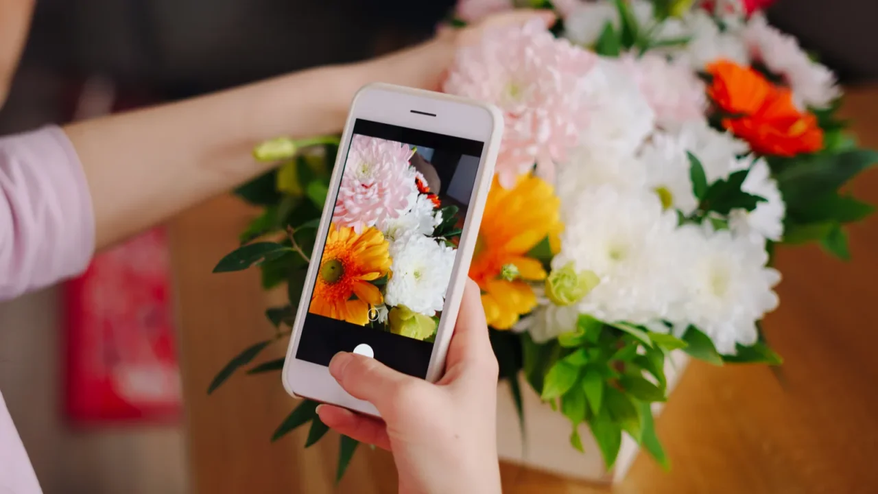 woman taking picture flower composition on smartphone