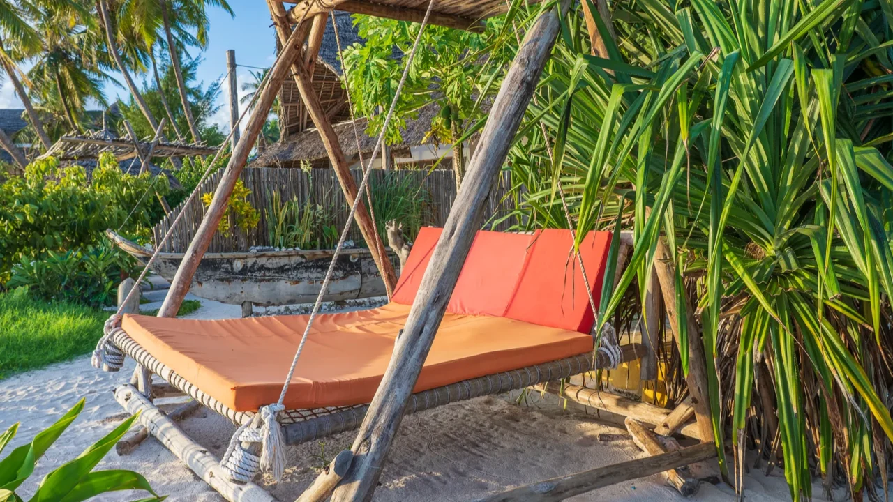 wooden swing with a mattress under a canopy on the