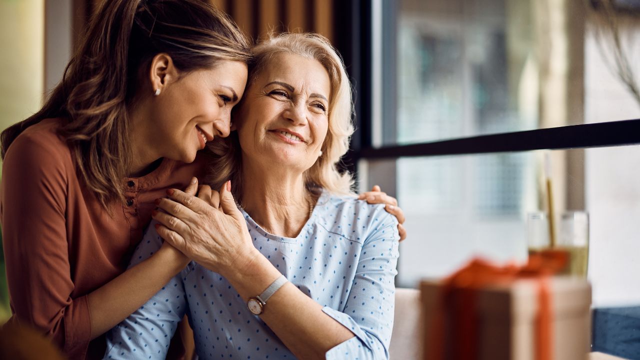 Two women sharing a joyful, affectionate moment indoors.