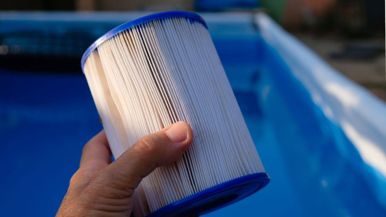A person holding new pool filter in his hand.