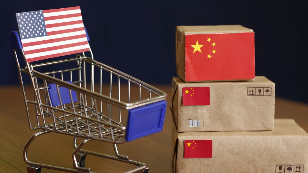 A shopping cart decorated with an American flag, placed next to boxes with Chinese flags.