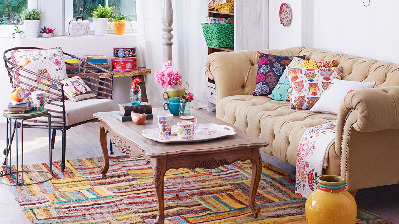 Bright, cozy living room with floral and patterned cushions, and a vintage coffee table.