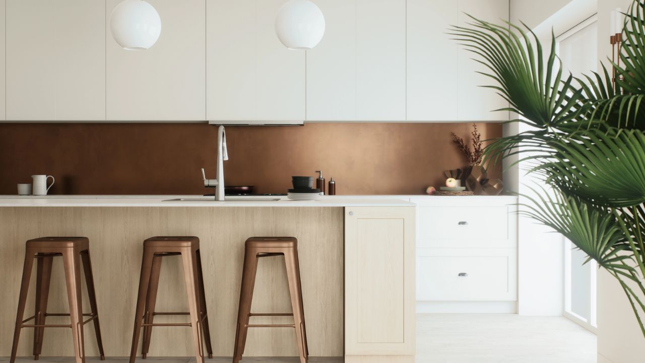 Bright kitchen with white cabinets, copper backsplash, and a large plant.